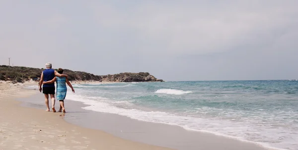 Koppel wandelen op het strand — Stockfoto