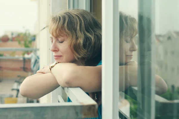 Frau steht am Fenster — Stockfoto