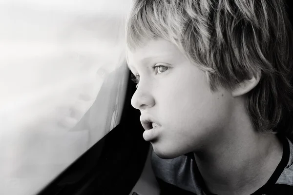 Ragazzo guardando attraverso la finestra — Foto Stock