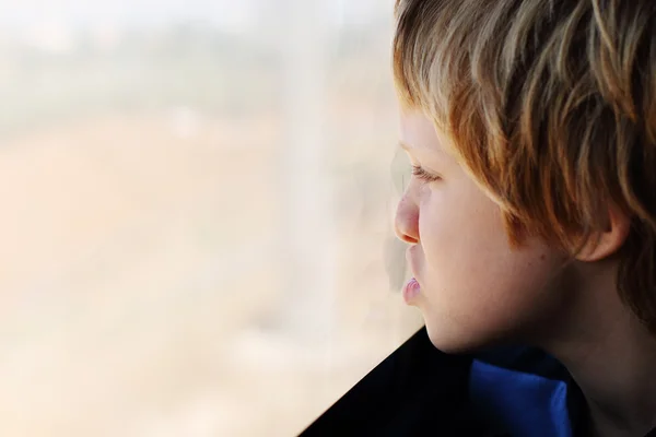 Pojken tittar genom fönstret — Stockfoto