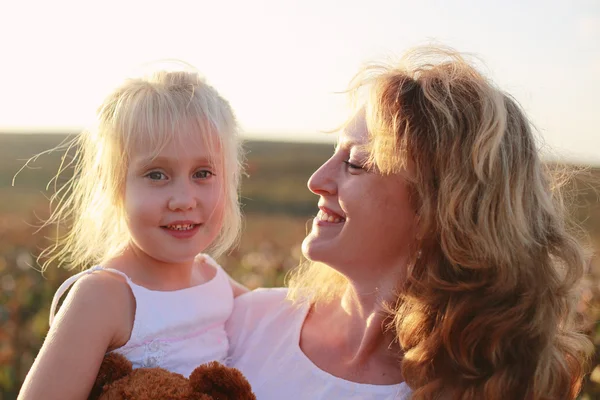 Glad mamma med dotter på fältet — Stockfoto