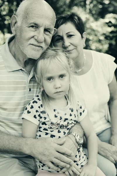Mor-och farföräldrar med barnbarn i park — Stockfoto