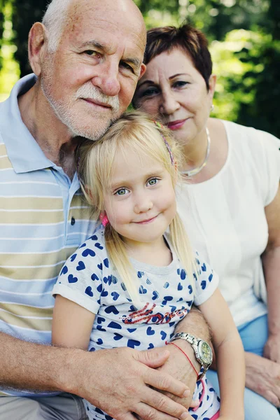 Mor-och farföräldrar med barnbarn i park — Stockfoto