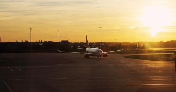 Літак в аеропорту на заході сонця — стокове фото
