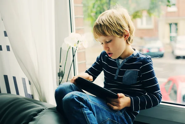 Маленький мальчик играет на планшете — стоковое фото