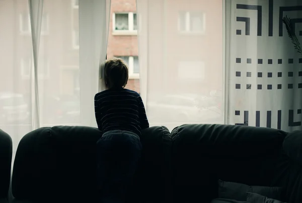 Little boy sitting near window — Stock Photo, Image