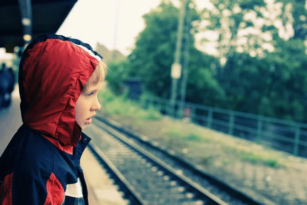 Niño de pie en la estación de tren — Foto de Stock