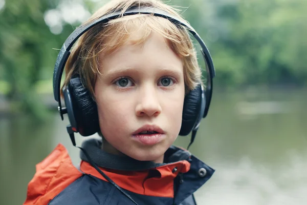 Ładny autystyczny chłopiec ze słuchawkami — Zdjęcie stockowe