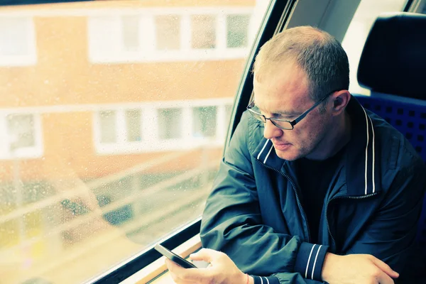 Pohledný muž držící smartphone a cestování — Stock fotografie