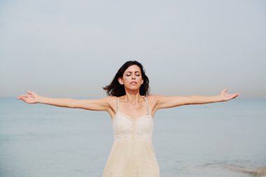 Kumlu sahilde duran kadın