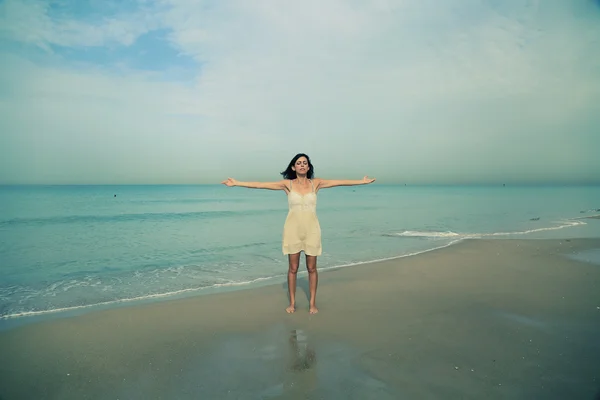 Mujer de pie en la orilla de la playa — Foto de Stock