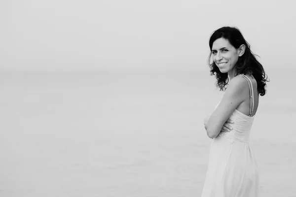 Kobieta stojąc na brzegu plaży — Zdjęcie stockowe