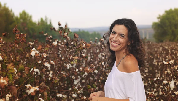 Beautiful woman standing in cotton fiel — Stock Photo, Image