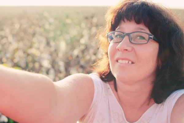 Mulher no campo e fazendo selfie . — Fotografia de Stock