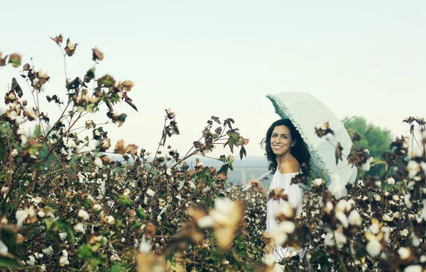Mulher segurando guarda-chuva no campo de algodão — Fotografia de Stock