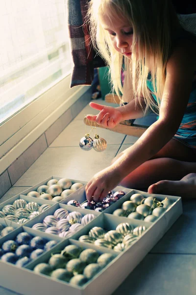 Girl is playing with christmas balls — Stock Photo, Image