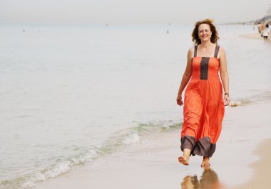 Kumsalda yürüyen bir kadın