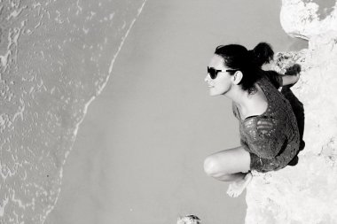 Kumsalda oturan kadın.