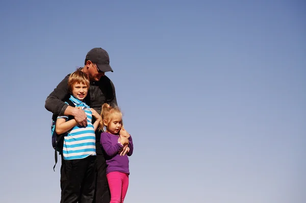 Отец стоит с двумя детьми — стоковое фото
