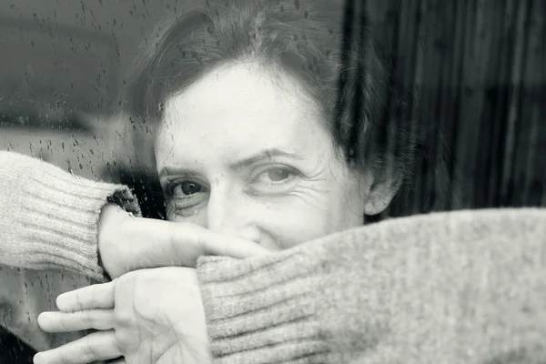 Frau schaut aus dem Fenster — Stockfoto