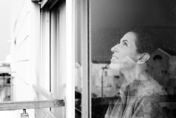 Frau schaut aus dem Fenster — Stockfoto