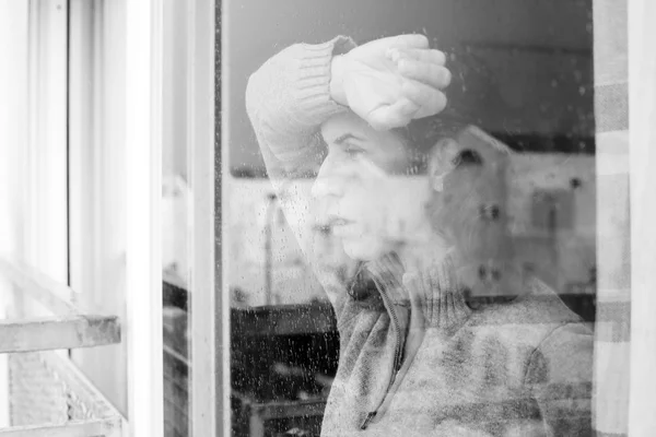 Frau schaut aus dem Fenster — Stockfoto