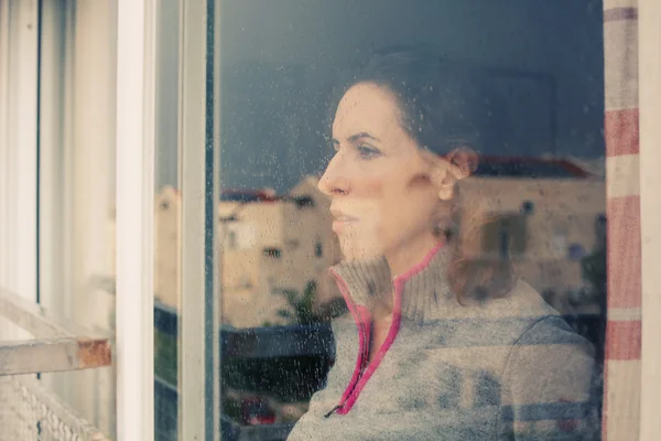 Frau schaut aus dem Fenster — Stockfoto