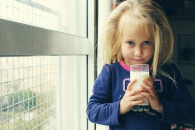 bir bardak süt ile küçük kız