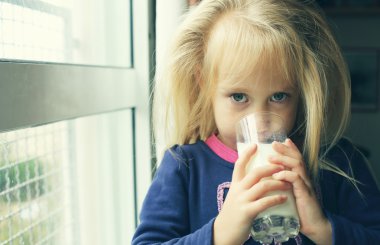 bir bardak süt ile küçük kız