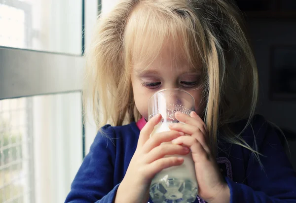 Маленька дівчинка зі склянкою молока — стокове фото