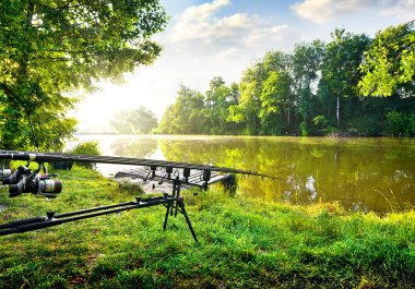 Fishing rods near river clipart