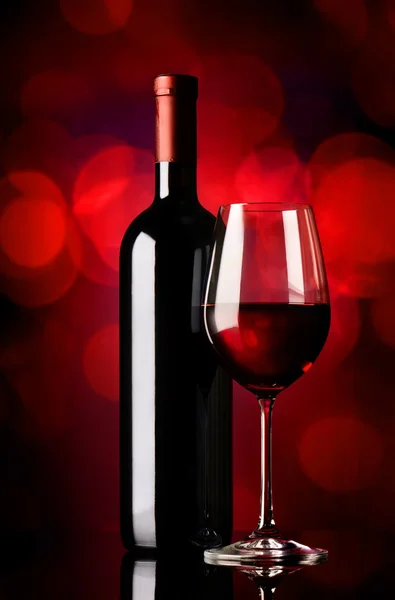 Bottiglia con vino su rosso — Foto Stock