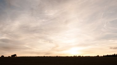 Yaz günbatımı bir tarım arazisi üzerinde