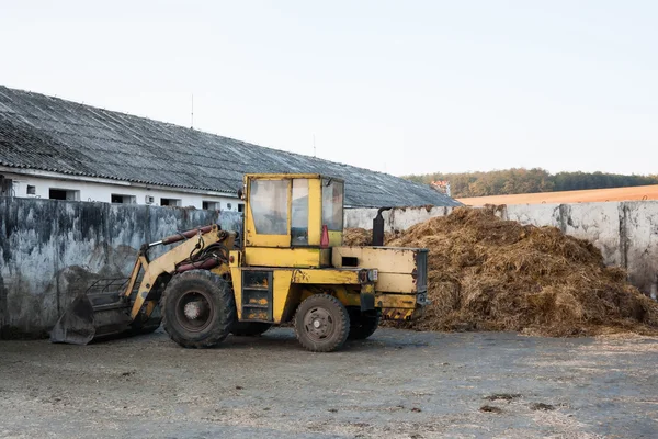 Vieux bulldozer près du tas de fumier — Photo