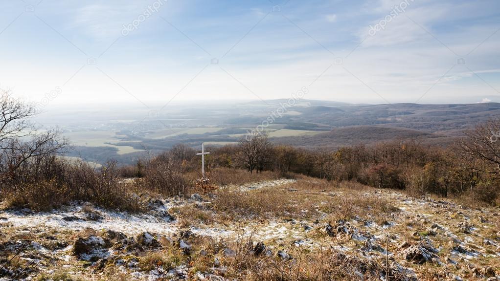 Cross on hill above rural countryside