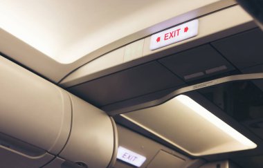 Acil çıkış levhası ve uçakta tuvalet tabelası.