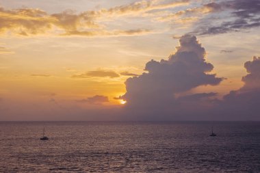 Gün batımında gökyüzü ve bulutların arasında güneş olan sakin bir deniz. Meditasyon okyanusu ve gökyüzü arka planı