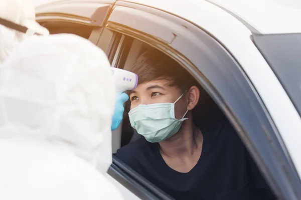 Asian Woman Drive Thru Covid-19 Testing With PPE Medical Staff, COVID testing temp while checking in cars