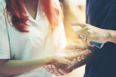 Koronavirüs Covid-19 'un yayılmasını önlemek için maske takan Asyalılar ellerinde dezenfektan alkolü tutuyorlar.