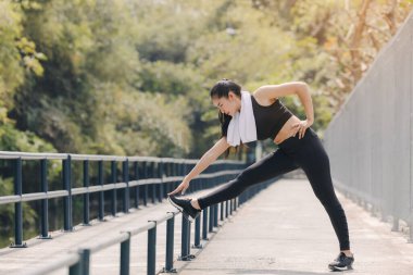 Koşu yaptıktan sonra vücudunu esneten genç bir kadın rıhtımda koşan mutlu, sportif bir kadın.
