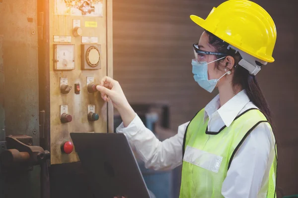 Industrial factory maintenance engineers woman inspect relay protection system of machinery and holding notebook with copy space. Industry, Maintenance, Engineering and construction concept.