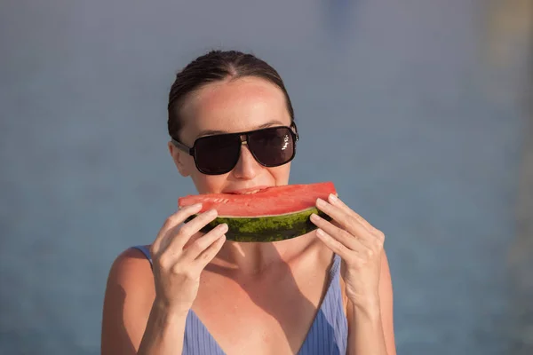 Very beautiful woman with watermelon in the pool