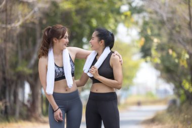 İki güzel bayan koşucu, parkta gerinen kız arkadaşlar.
