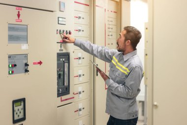 Mühendis ya da elektrikçinin elini kapat. Fabrikadaki elektrik sistemini tabletle kontrol et..