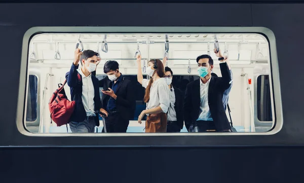 People on the train wear anti-virus masks and travel during rush hours. passengers inside the Sky Train with the masks on all people\'s faces.