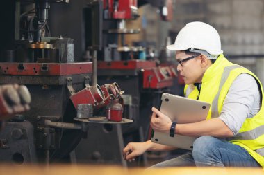 Mühendis ya da cerrahi maske takan teknisyenler kontrol için bilgisayar defteri kullanıyorlar.