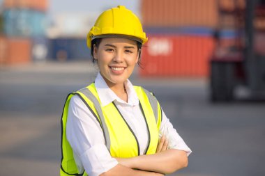 Lojistik mühendisi kadın ustabaşı portresi. Kargo konteynırlarında kasketli ve güvenlikli.