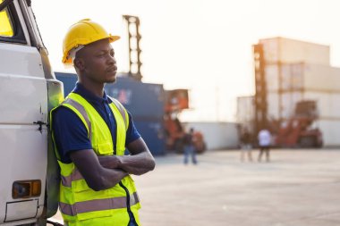 Bir arabanın bagajında duran siyah bir işçi.