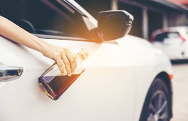 Araba camından viski şişesi tutan kadın, alkollü araç kullanan kadın., 