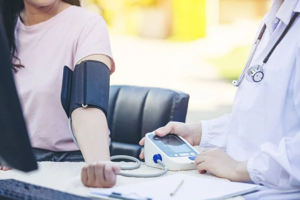 Female Doctor Measuring Blood Pressure Of women patient social service in  local village Thailand.